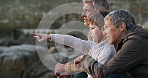 Boy bonding and sitting with his grandparents at the beach while discussing what they see. Building a natural