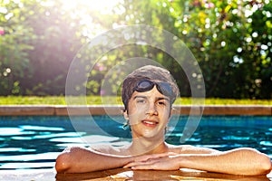 Boy on the border of swimming pool with googles photo