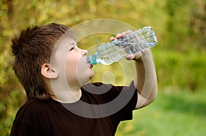 Boy with a bottle of water in nature