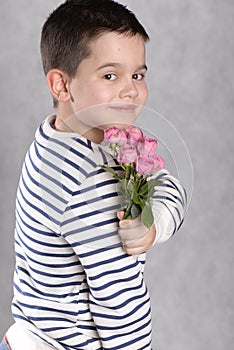 A boy with a bouquet of small pink roses in his hands. concept greetings for mother`s day,