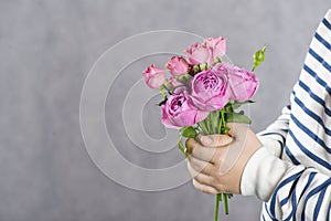 A boy with a bouquet of small pink roses in his hands. concept greetings for mother`s day,