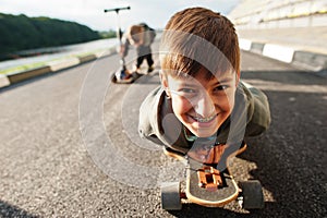 Boy with braces lying on a skateboard, close up portrait