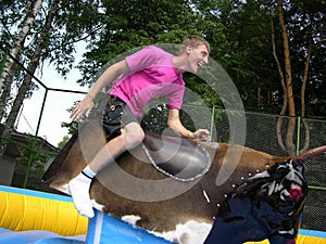 Boy on bull simulator photo