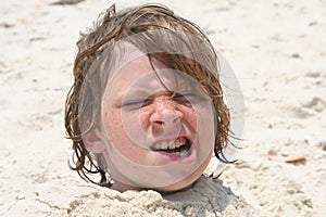 Boy buried in the sand