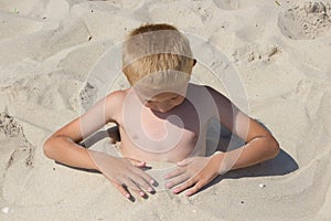 Boy buries itself in the sand