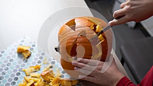 Boy busy carving a pumpkin jack-o-lantern for Halloween - removing the seeds