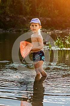 Boy with a butterfly net and a flower going down the river