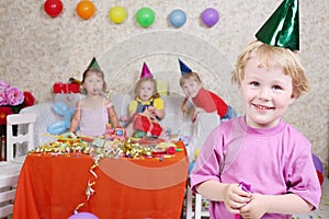 Boy in cap and with party blowers smiles at