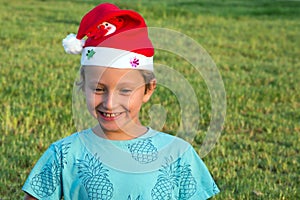 Boy in cap of Santa Claus smiles