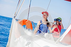 Boy captain with his sister on board of sailing yacht on summer cruise. Travel adventure, yachting with child on family