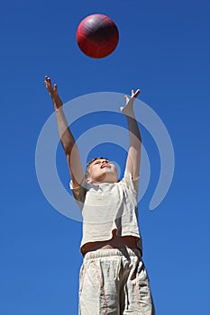 Boy carrom ball upwards and catches him