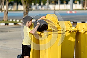 Boy carry garbage in bag for eliminate to the bin photo