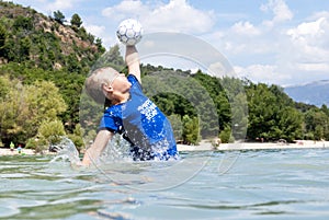 Boy catching a ball in a lake