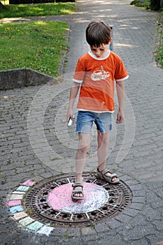 Boy chalking the street