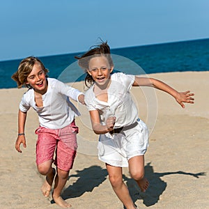 Boy chasing girl on beach.