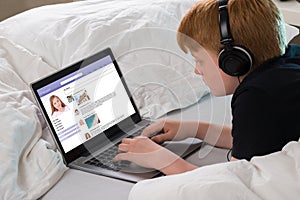 Boy Chatting On Social Networking Site Using Laptop