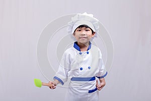 Boy in chef uniform on white background