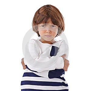 Boy, child and angry in portrait with arms crossed, frustrated and stress, emotion and frown on white background. Youth