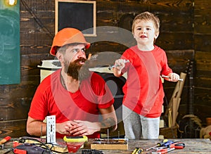 Boy, child cheerful holds bolts or screws, having fun while handcrafting with dad. Handyman concept. Father, parent with