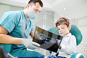 Boy child and dentist look at x-ray image