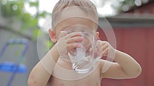 Boy child drank water from a transparent glass