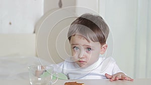 Boy child eating cookies sitting at table