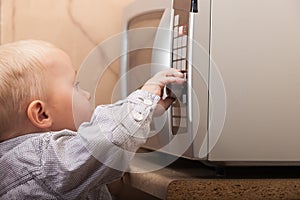 Boy child kid playing with timer of microwave oven