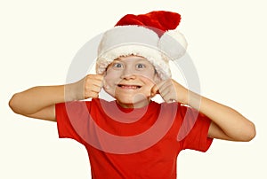 Boy child make faces in santa hat, having fun and emotions, winter holiday concept, yellow toned