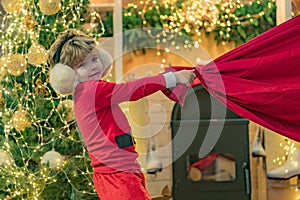Boy child play near christmas tree. Wish to meet santa claus. Adorable child play Santa at home. Lovely baby enjoy