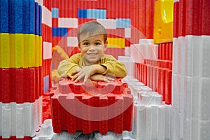 Boy child playing with huge building blocks in entertainment center