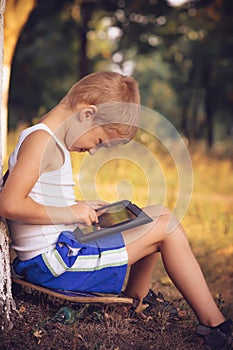 Boy Child playing with Tablet PC Outdoor