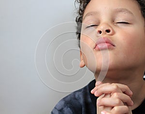 Boy child praying to God with hands together stock photo
