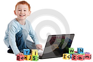 Boy child at school with computer and kids blocks