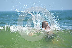 Boy child swim in sea. A boy swims in the open ocean. Learning to swim in the salty sea. Summer vacation in the tropics.