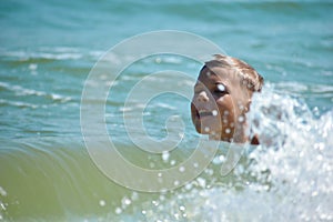 Boy child swim in sea. A boy swims in the open ocean. Learning to swim in the salty sea. Summer vacation in the tropics.