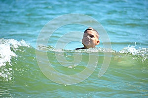 Boy child swim in sea. A boy swims in the open ocean. Learning to swim in the salty sea. Summer vacation in the tropics.