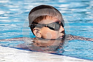 Boy child swimmer in swimming pool. Water sports, training, competition, summer activity, healthy lifestyle, kids sport