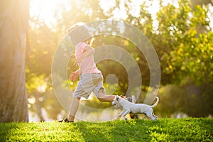 Boy child walk with puppy. Kid with pets running. Happy Child and dog runs at backyard lawn.