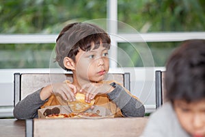 boy Children enjoy eating pizza in classroom school . kid hungry