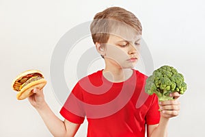 Boy chooses between fastfood and broccoli on white background