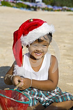 Boy with Christmas hat on beach