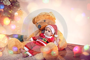 Boy in Christmas Santa`s costume with teddy bear  on Christmas day.Happy baby boy wearing santa clothes