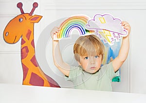 Boy in the class show weather cards with rain and rainbow