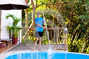 Boy cleaning swimming pool. Maintenance, service