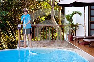 Boy cleaning swimming pool. Maintenance, service