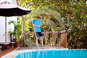 Boy cleaning swimming pool. Maintenance, service