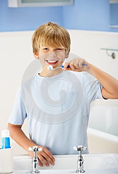 Boy cleaning teeth in bathroom