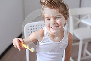 Boy cleans his teeth in the morning and plays with a toothbrush