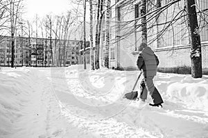 A boy cleans snow near a house in St. Petersburg