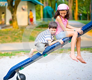 Boy climb on the slide with sister